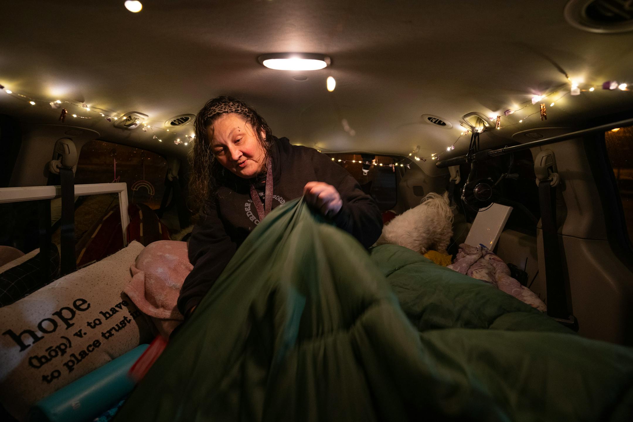 Fresh from the shower, Lynette Ruse got her bedding sorted out before going to sleep in her van Monday night, October 30, 2023 in Duluth. At night, the parking lot of the Damiano Center becomes Safe Bay, a place where unhoused people can sleep in their vehicles without fear for their safety. A mobile hygiene trailer has showers and bathrooms for people to use before they settle in for the night. Safe Bay is an initiative of Stepping On Up, a  coalition of Duluth social service organizations, many of which are housed in the Damiano Center.   ]   JEFF WHEELER • Jeff.Wheeler@startribune.com